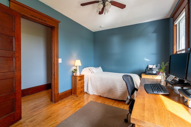 bedroom featuring wood finished floors, baseboards, a desk, and ceiling fan