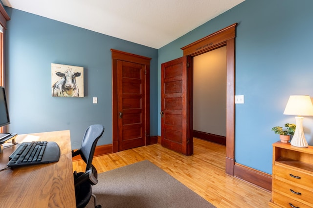 office area with light wood finished floors and baseboards