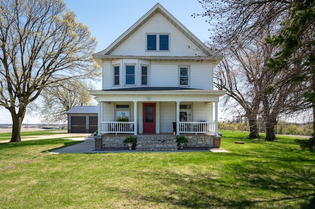 american foursquare style home featuring a porch, a detached garage, and a front yard