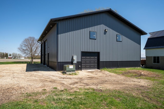 view of property exterior featuring a detached garage, an outbuilding, and board and batten siding