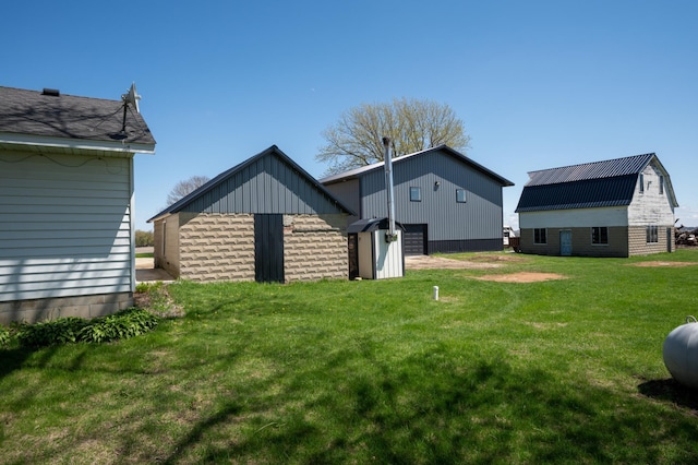 back of property with a lawn, an outdoor structure, and a barn