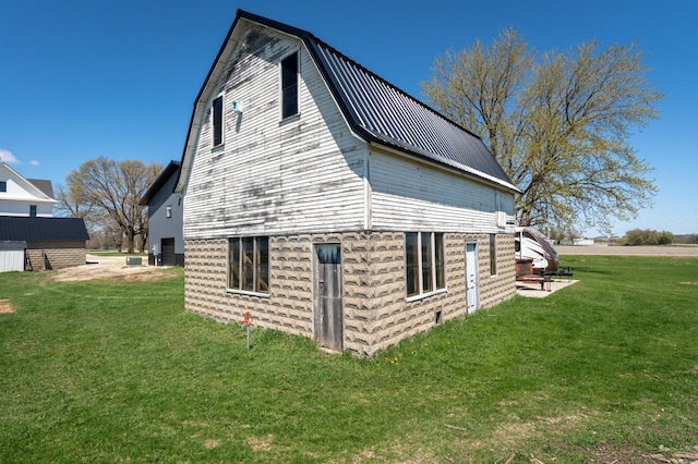 view of property exterior with a yard, a gambrel roof, and metal roof