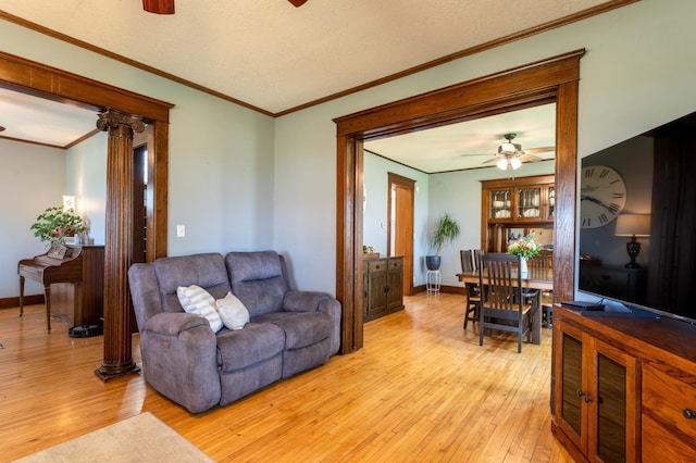 living room with ceiling fan, light wood-type flooring, crown molding, and baseboards