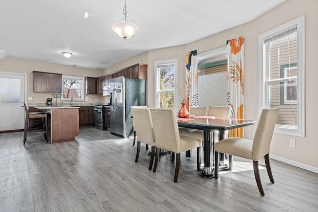 dining area featuring light wood-style floors and baseboards