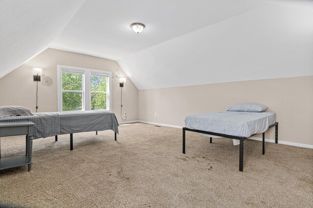 bedroom with vaulted ceiling, carpet floors, and baseboards
