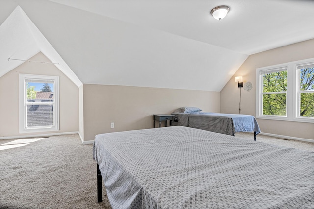 carpeted bedroom featuring lofted ceiling and baseboards