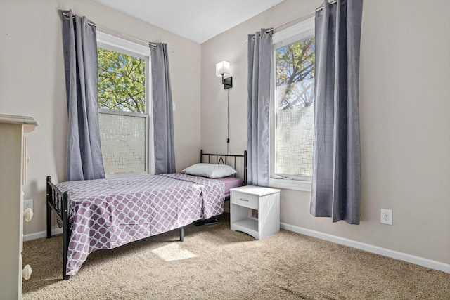 carpeted bedroom with multiple windows and baseboards
