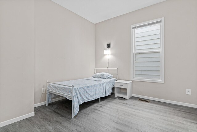 bedroom with wood finished floors and baseboards