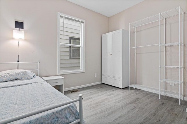 bedroom featuring light wood-type flooring and baseboards
