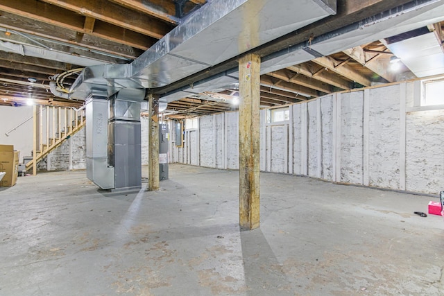 basement featuring stairway and heating unit