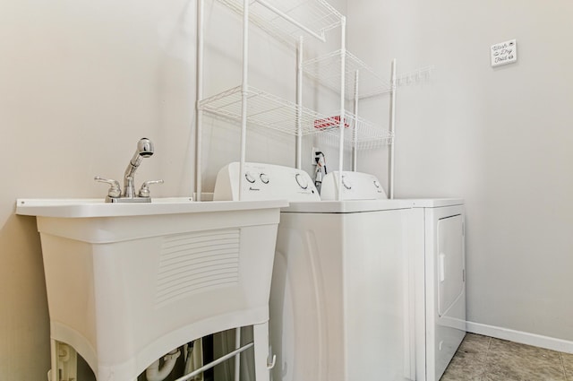washroom with washing machine and dryer and baseboards