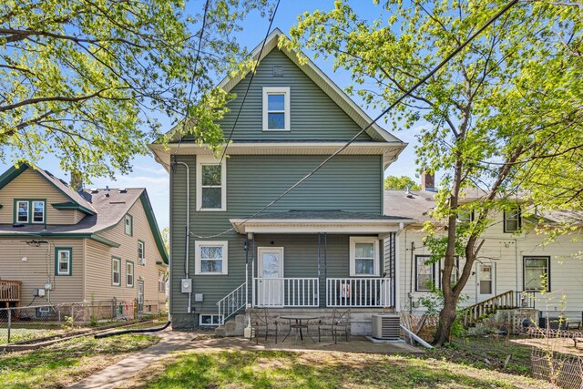 back of property featuring covered porch, central AC unit, and fence