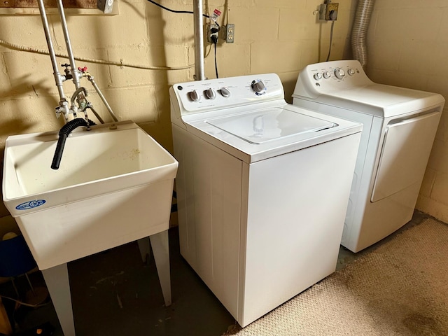 laundry room featuring concrete block wall, laundry area, and independent washer and dryer