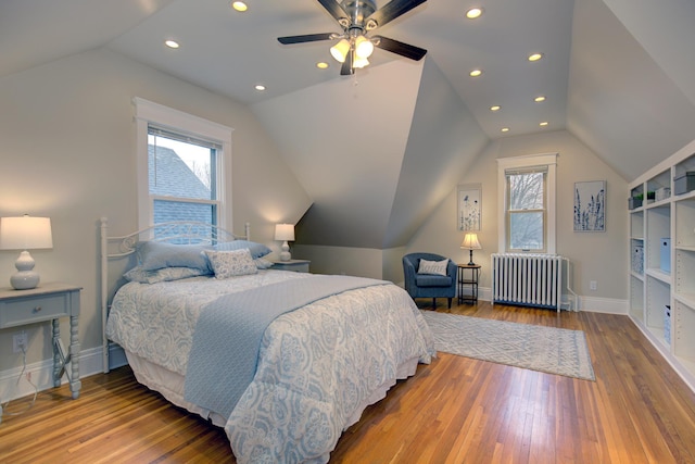 bedroom featuring radiator heating unit, lofted ceiling, wood-type flooring, baseboards, and recessed lighting