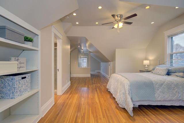 bedroom featuring light wood-style flooring, multiple windows, lofted ceiling, baseboards, and recessed lighting