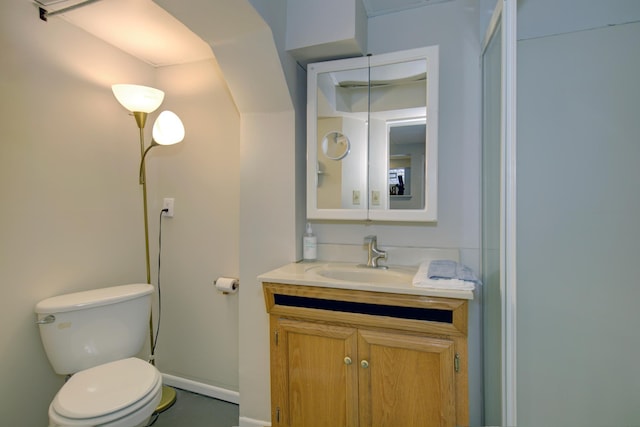 bathroom with vanity, toilet, and baseboards