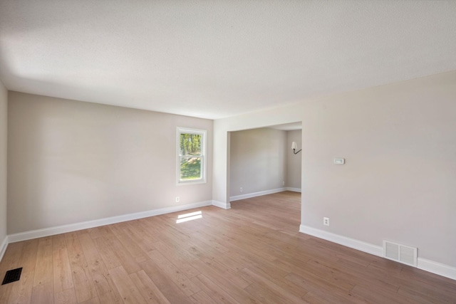 spare room with light wood-style flooring and baseboards