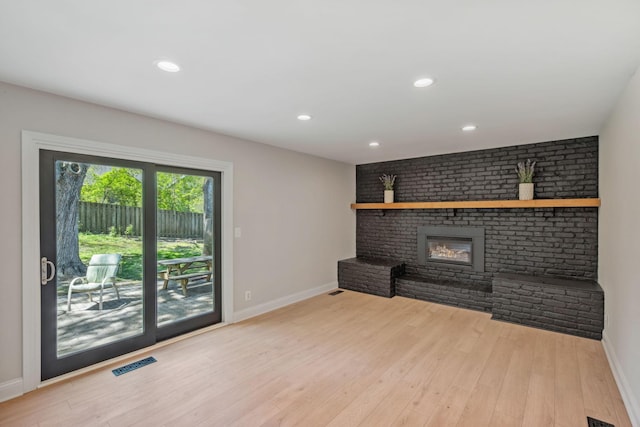 unfurnished living room featuring baseboards, a fireplace, wood finished floors, and recessed lighting