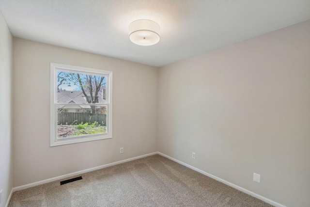 carpeted spare room featuring baseboards