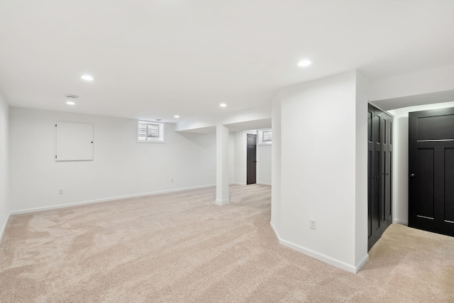 basement with light colored carpet, recessed lighting, and baseboards