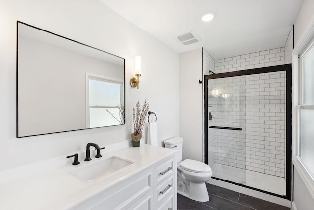 full bathroom with a shower stall, toilet, vanity, and tile patterned floors