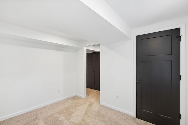 basement with baseboards and light carpet