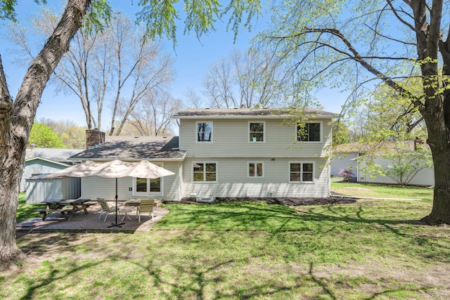 rear view of house featuring a patio and a lawn