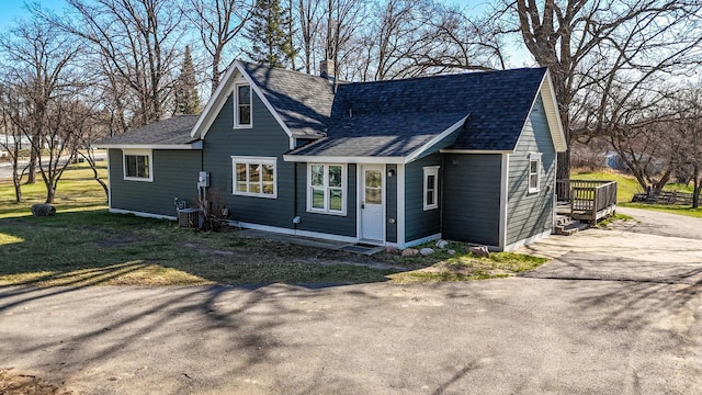 view of front of house with central AC, a chimney, a shingled roof, and aphalt driveway