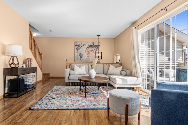 living room featuring stairway, baseboards, and wood finished floors