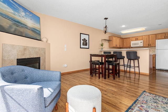living area featuring recessed lighting, baseboards, light wood-style flooring, and a fireplace