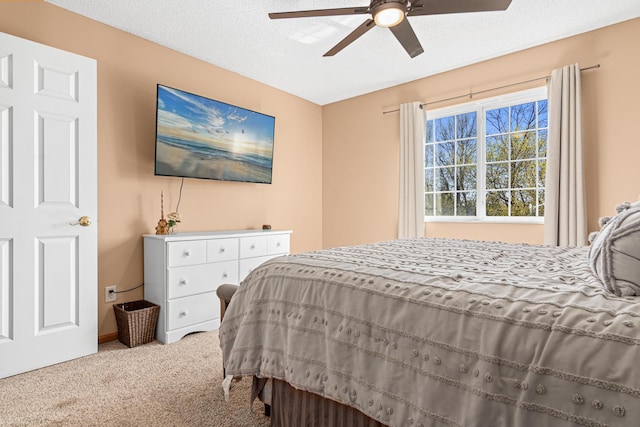 carpeted bedroom featuring baseboards, a textured ceiling, and ceiling fan