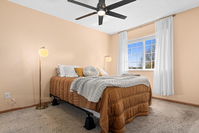 bedroom with baseboards, carpet flooring, a textured ceiling, and a ceiling fan