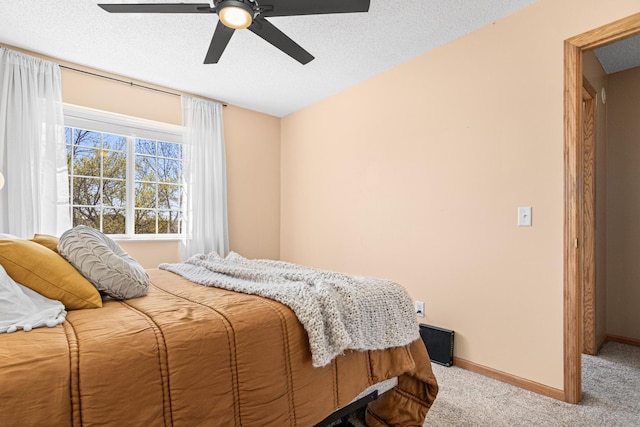 bedroom featuring baseboards, a textured ceiling, carpet, and a ceiling fan