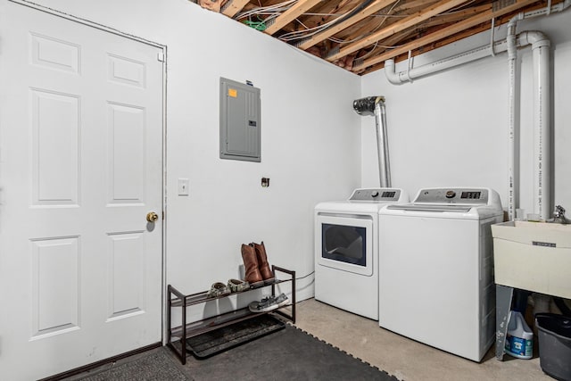 clothes washing area with laundry area, a sink, electric panel, and washer and dryer