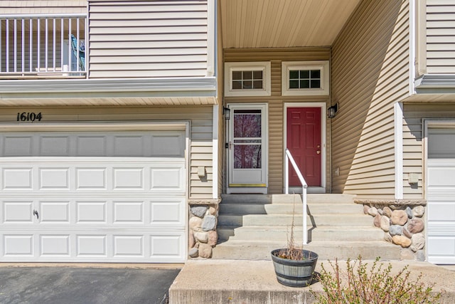 doorway to property with a garage and aphalt driveway