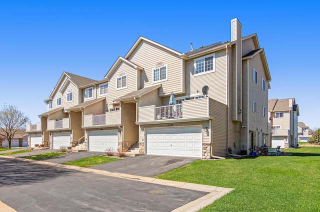 townhome / multi-family property with a chimney, a garage, driveway, and a residential view