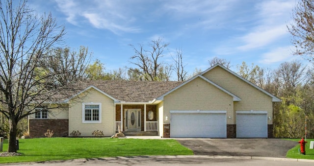 ranch-style home featuring an attached garage, driveway, a front lawn, and brick siding