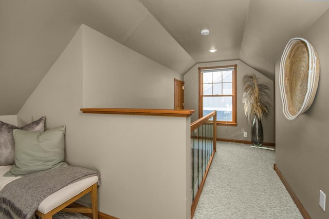 corridor with baseboards, lofted ceiling, light carpet, and an upstairs landing