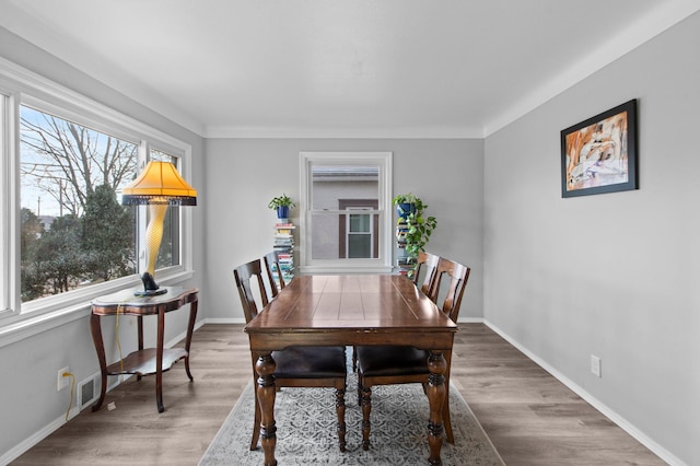 dining area with baseboards and wood finished floors