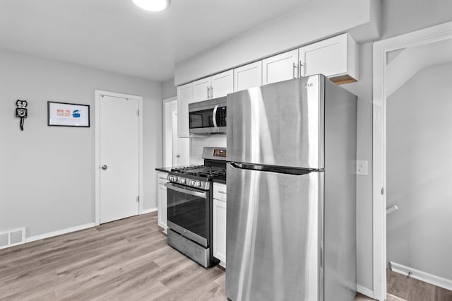 kitchen featuring visible vents, appliances with stainless steel finishes, baseboards, white cabinets, and light wood-style floors