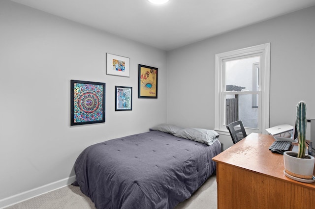 bedroom with baseboards and light colored carpet