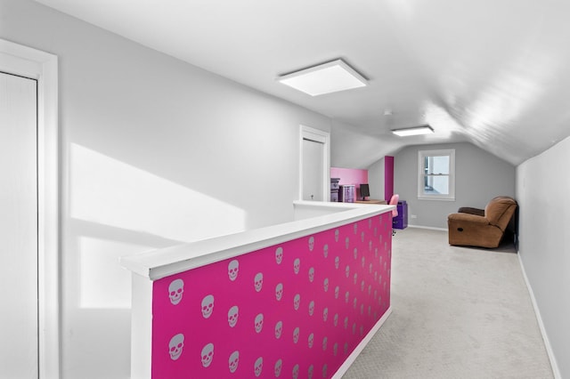 interior space with carpet flooring, baseboards, and vaulted ceiling