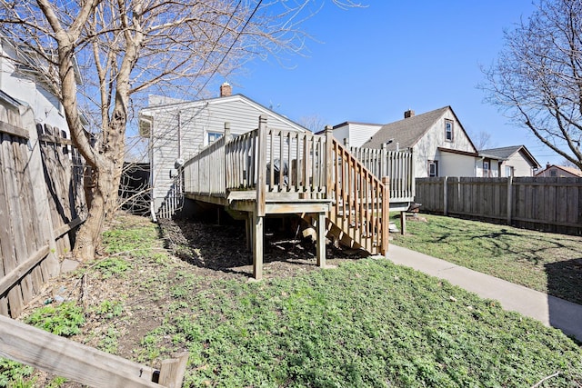 back of property with stairs, a fenced backyard, a wooden deck, and a yard