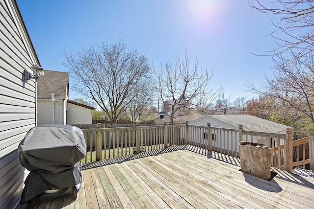 wooden terrace featuring a fenced backyard and a grill