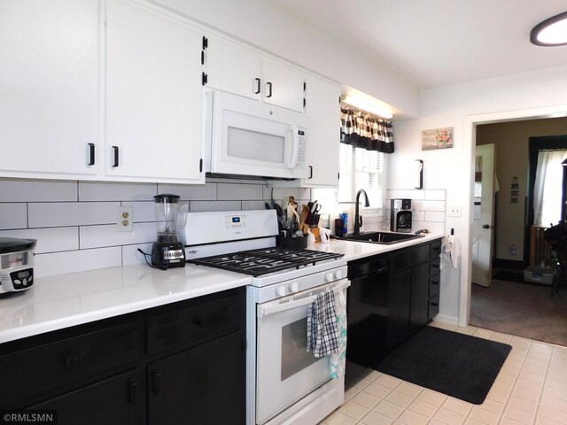 kitchen with white appliances, tasteful backsplash, a sink, and light countertops