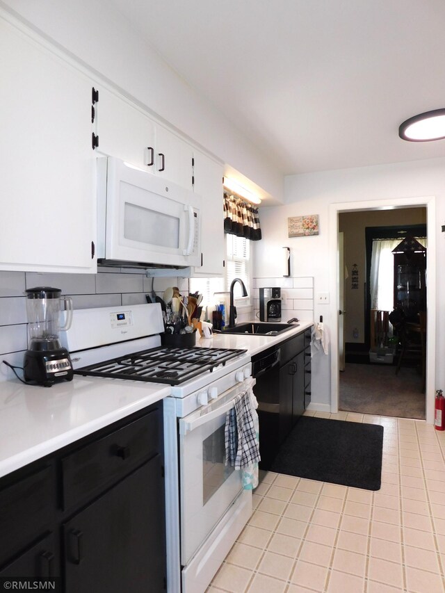 kitchen with white appliances, light tile patterned floors, a sink, and light countertops