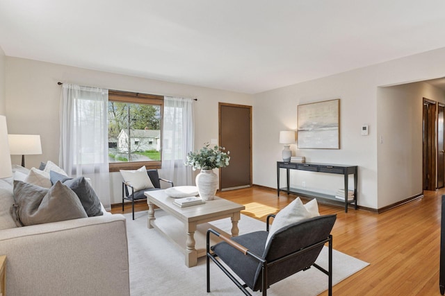living area with baseboards and light wood-type flooring