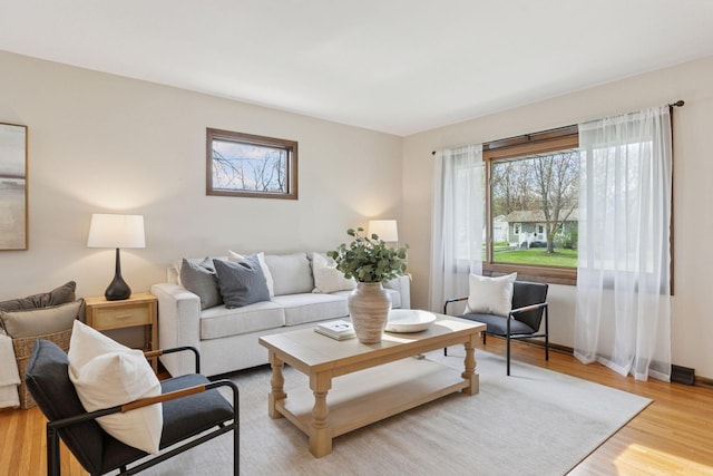 living area with light wood-type flooring and baseboards
