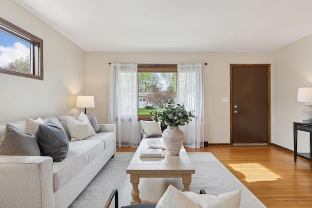 living area with baseboards and light wood finished floors