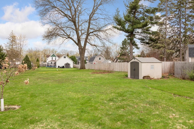 view of yard with a storage unit, an outdoor structure, and a fenced backyard